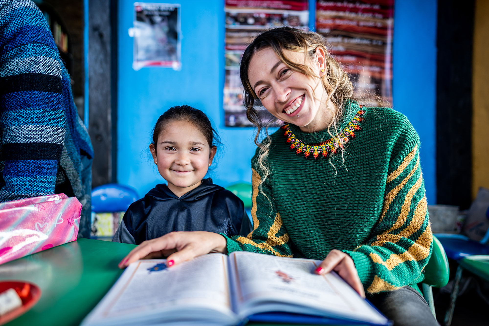 Portrait of a teacher reading a book with child student at a children’s foundation