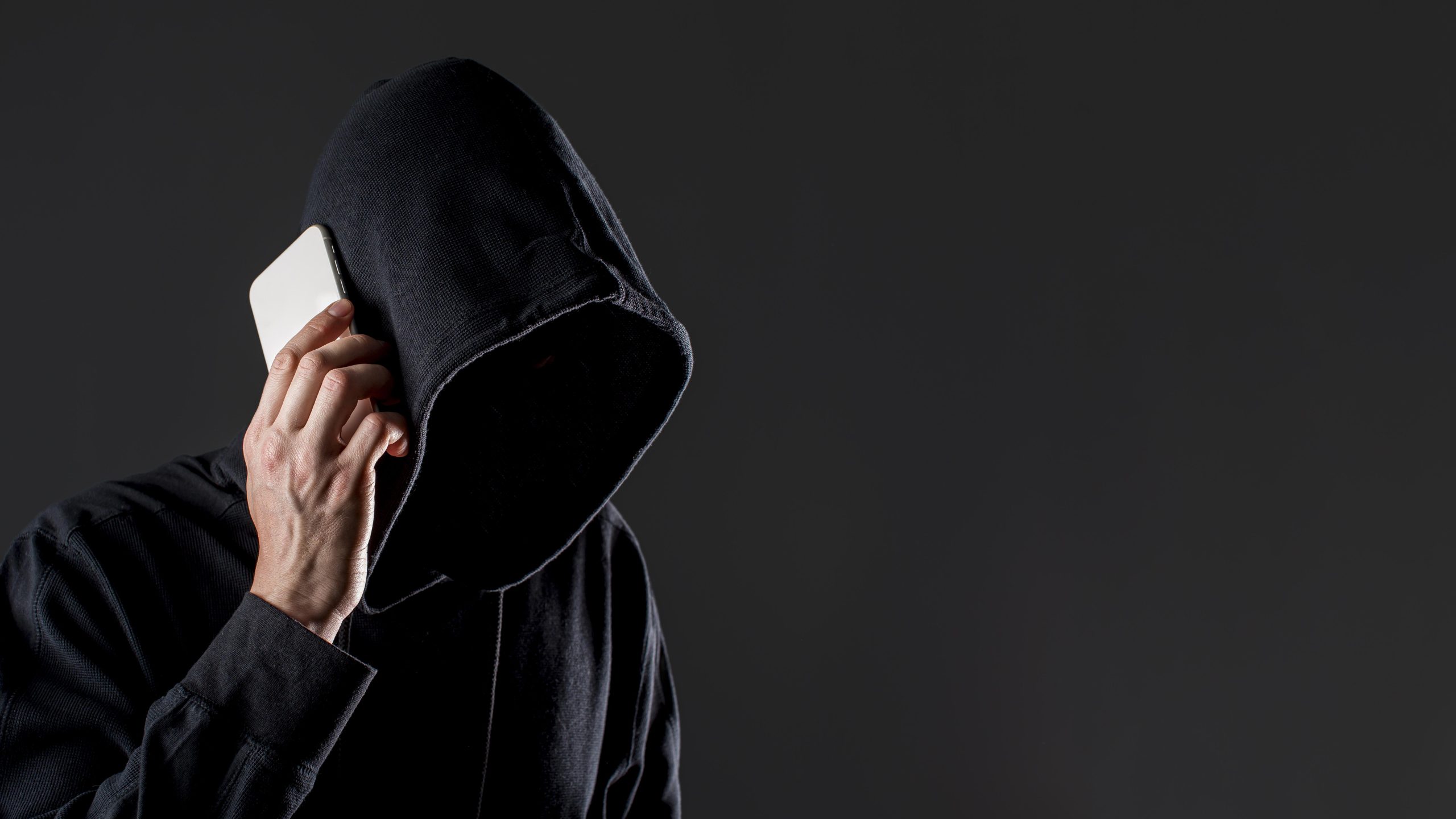 side-view-male-hacker-talking-smartphone-with-copy-space